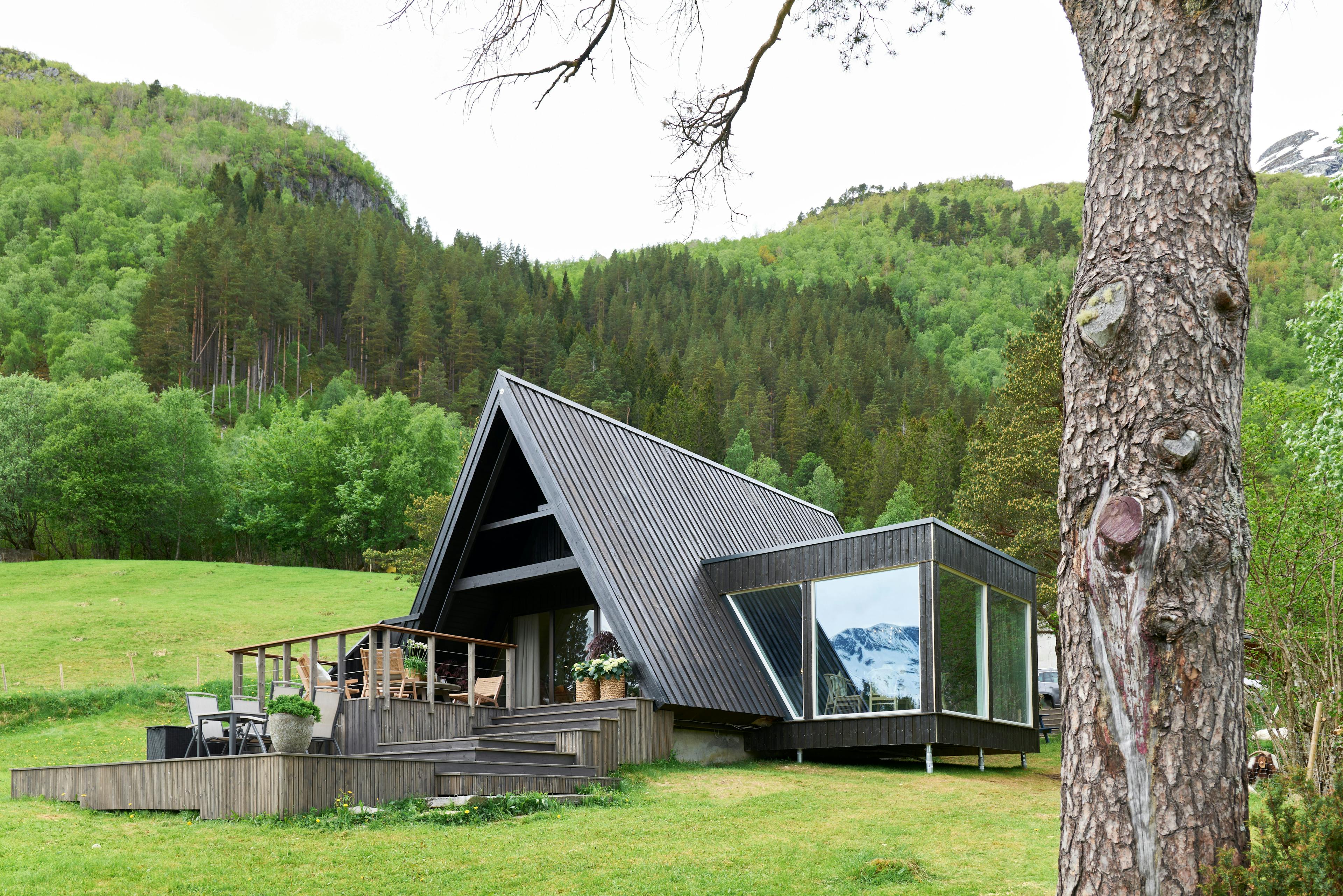 Hytte med store vinduer og skråtak