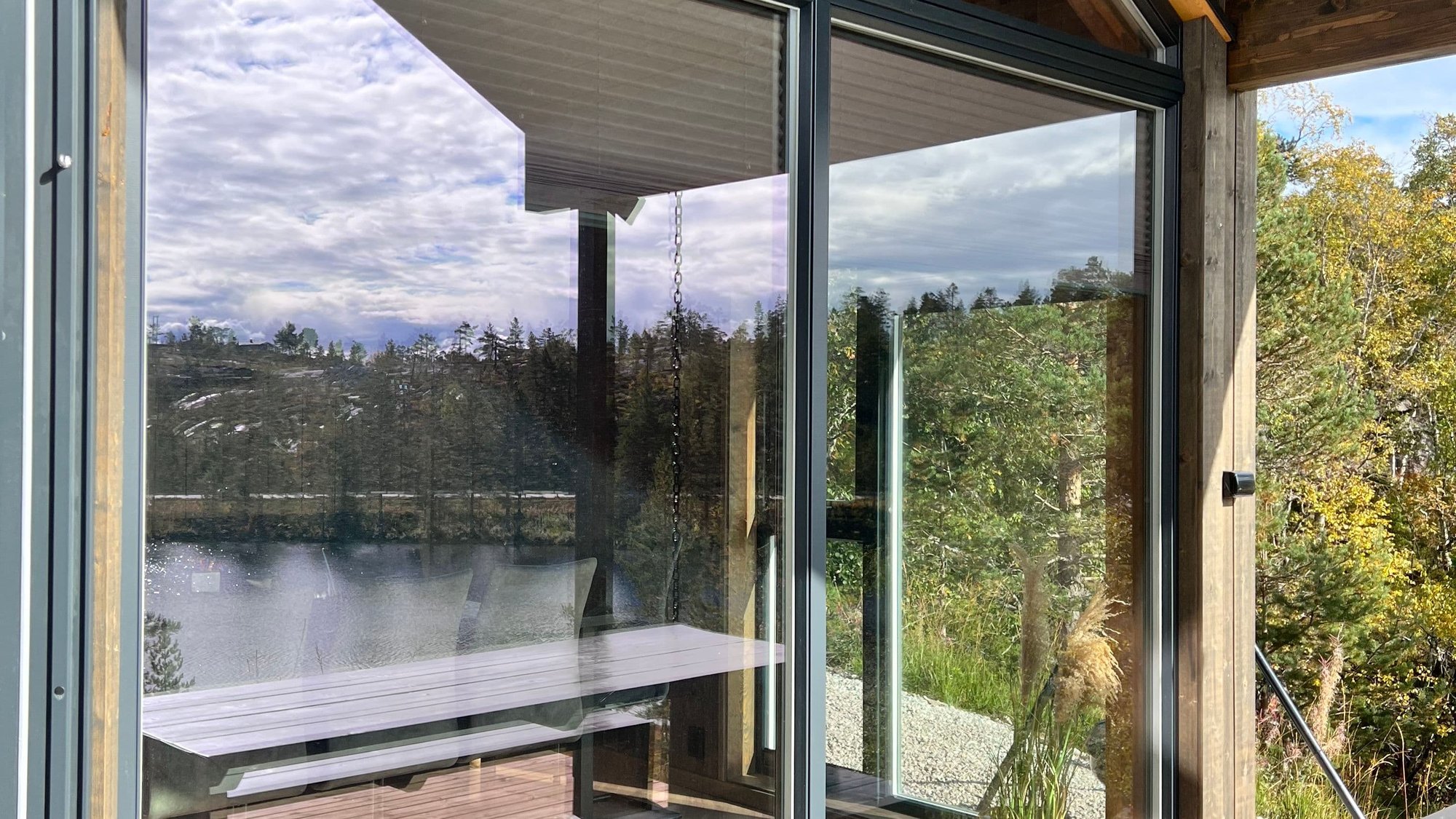 Natur som speiler seg i vindu på hytte
