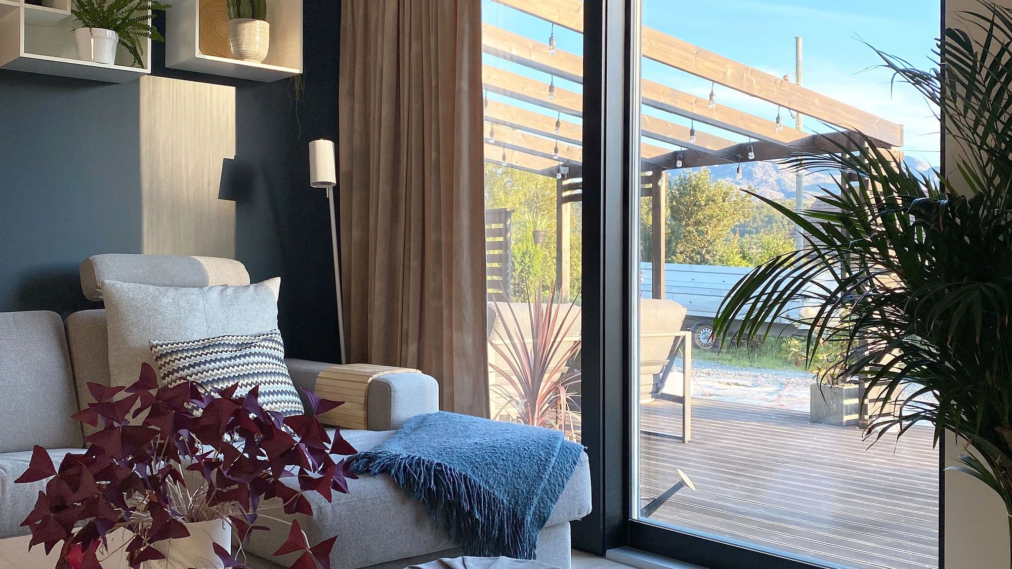 Sofa og bord med sort heve-/skyvedør ut mot veranda