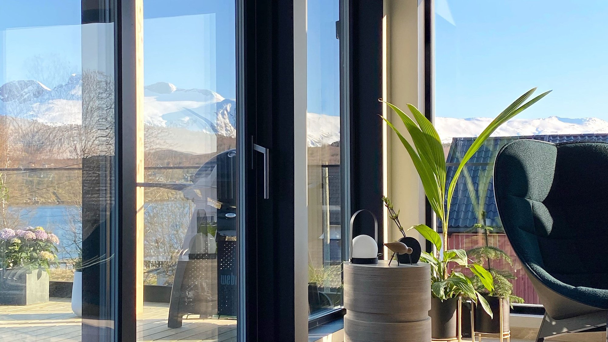 Store vinduer i sort med fjell utenfor