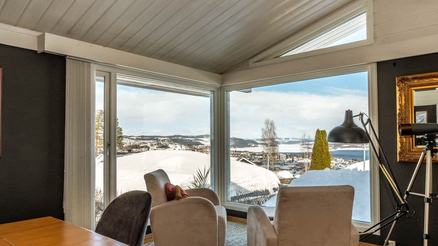 To lenestoler står foran store vinduer med vinter utenfor
