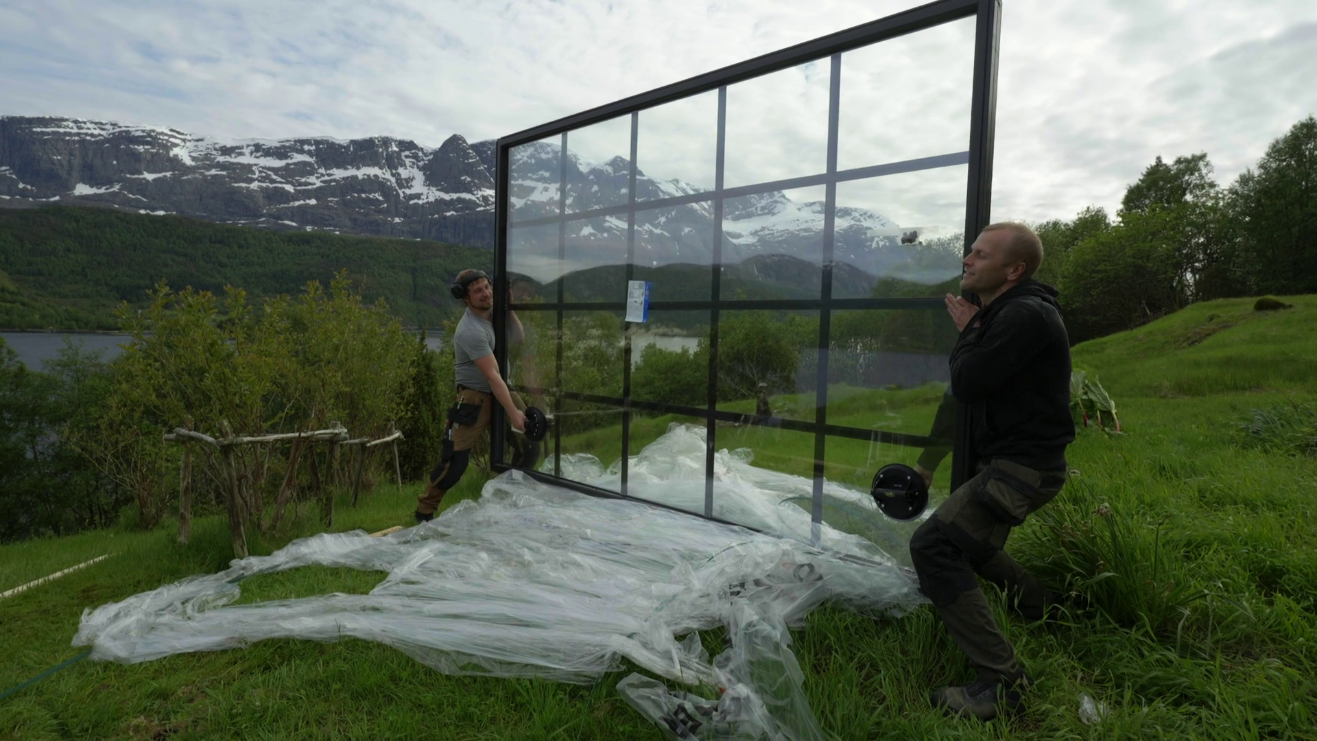 Stort fastkarmvindu monteres med utsikt mot fjord og fjell.