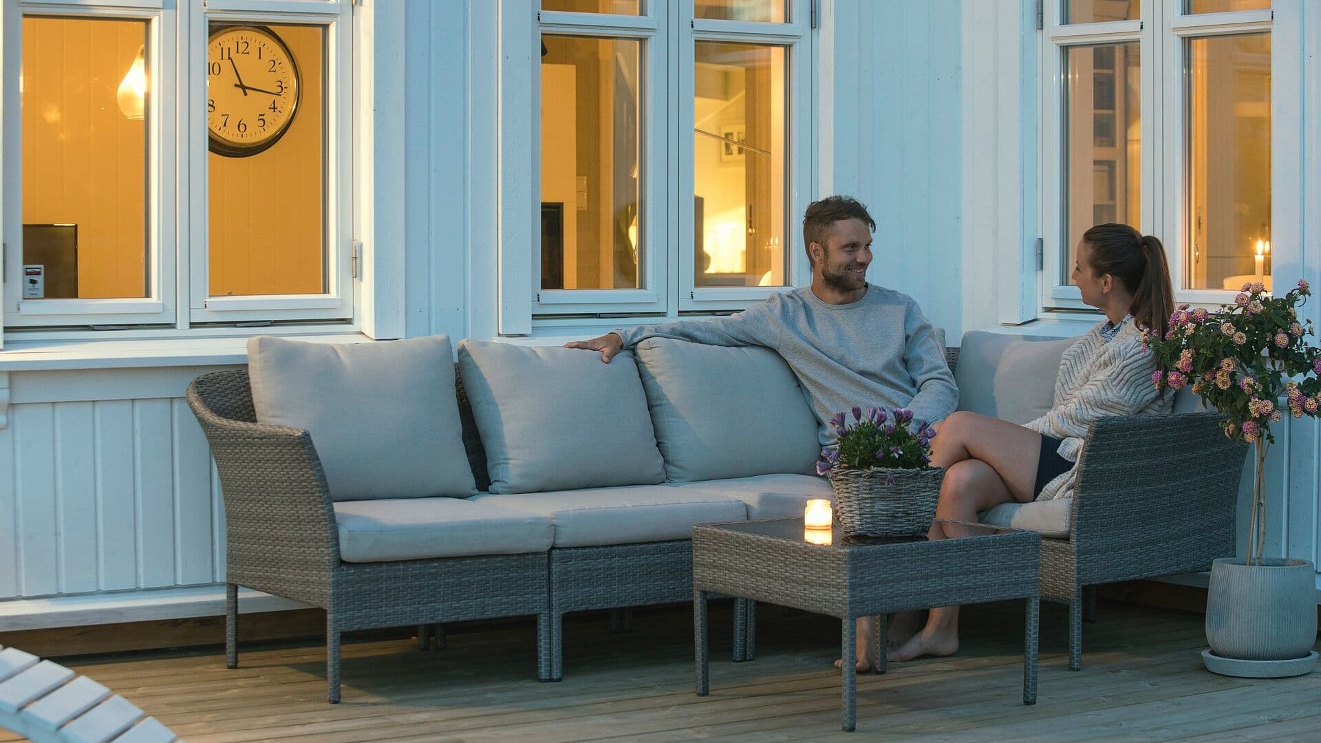 Par sitter utenfor et hus om kvelden
